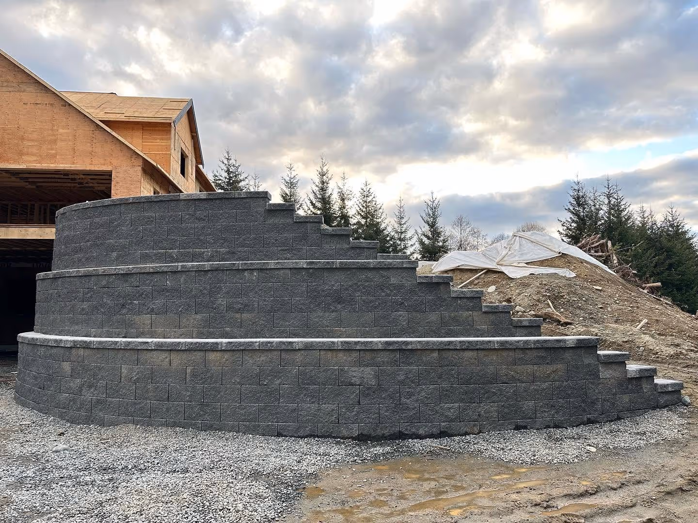 Tiered charcoal block retaining wall with curved steps at a Nanaimo home