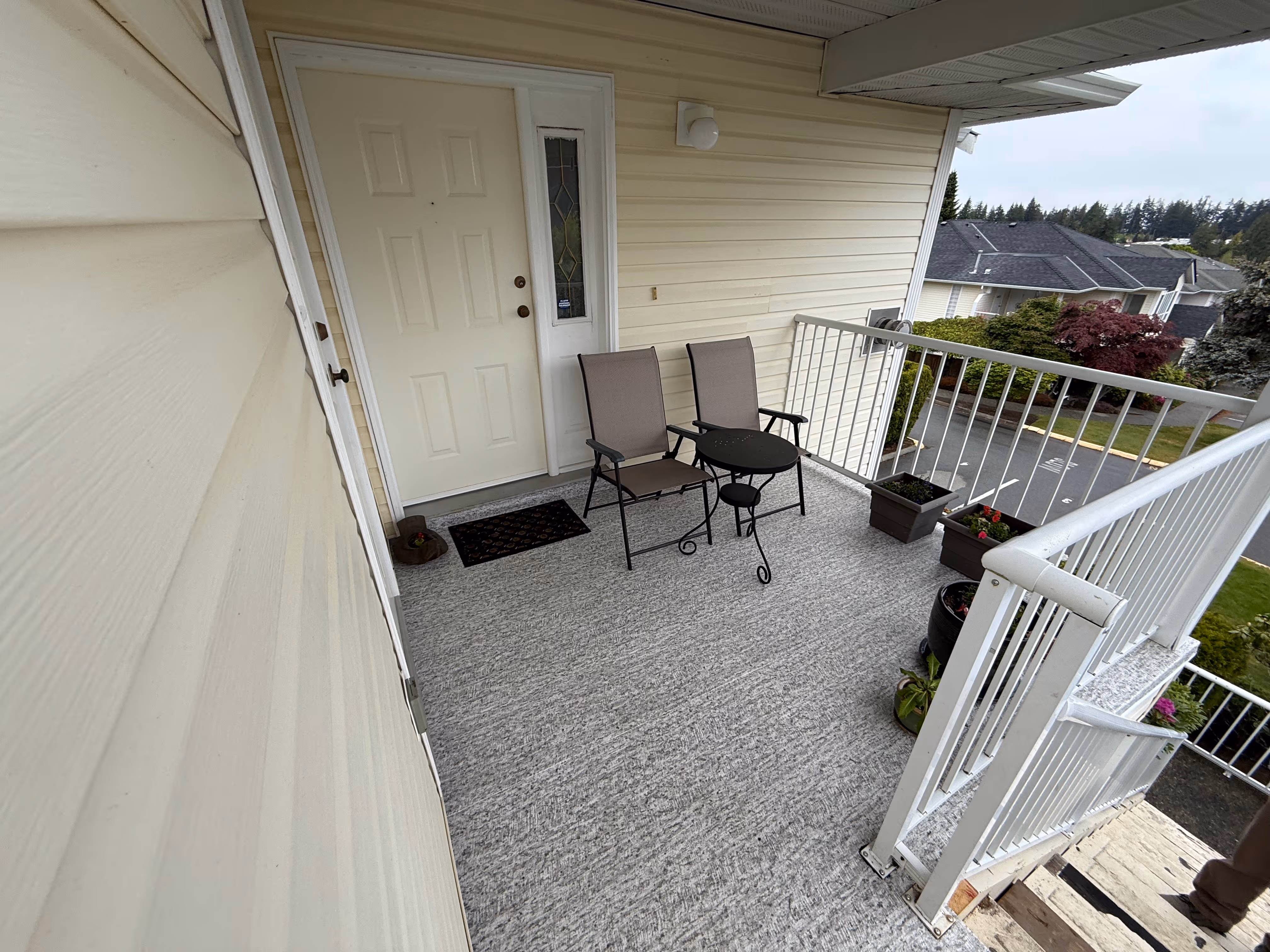 Covered entry deck with vinyl surfacing and aluminum railing