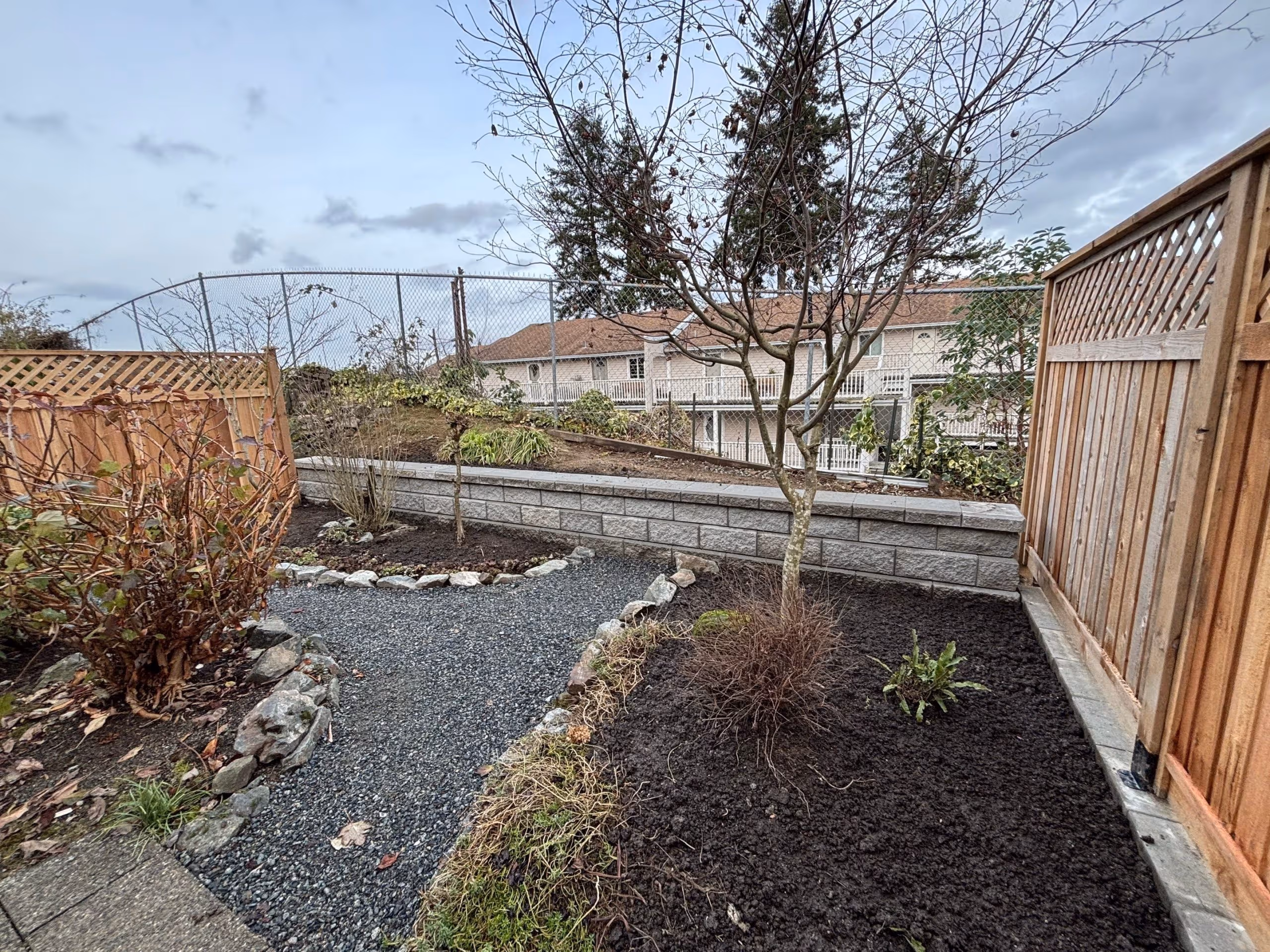 Low block retaining wall with a gravel path in a Nanaimo backyard