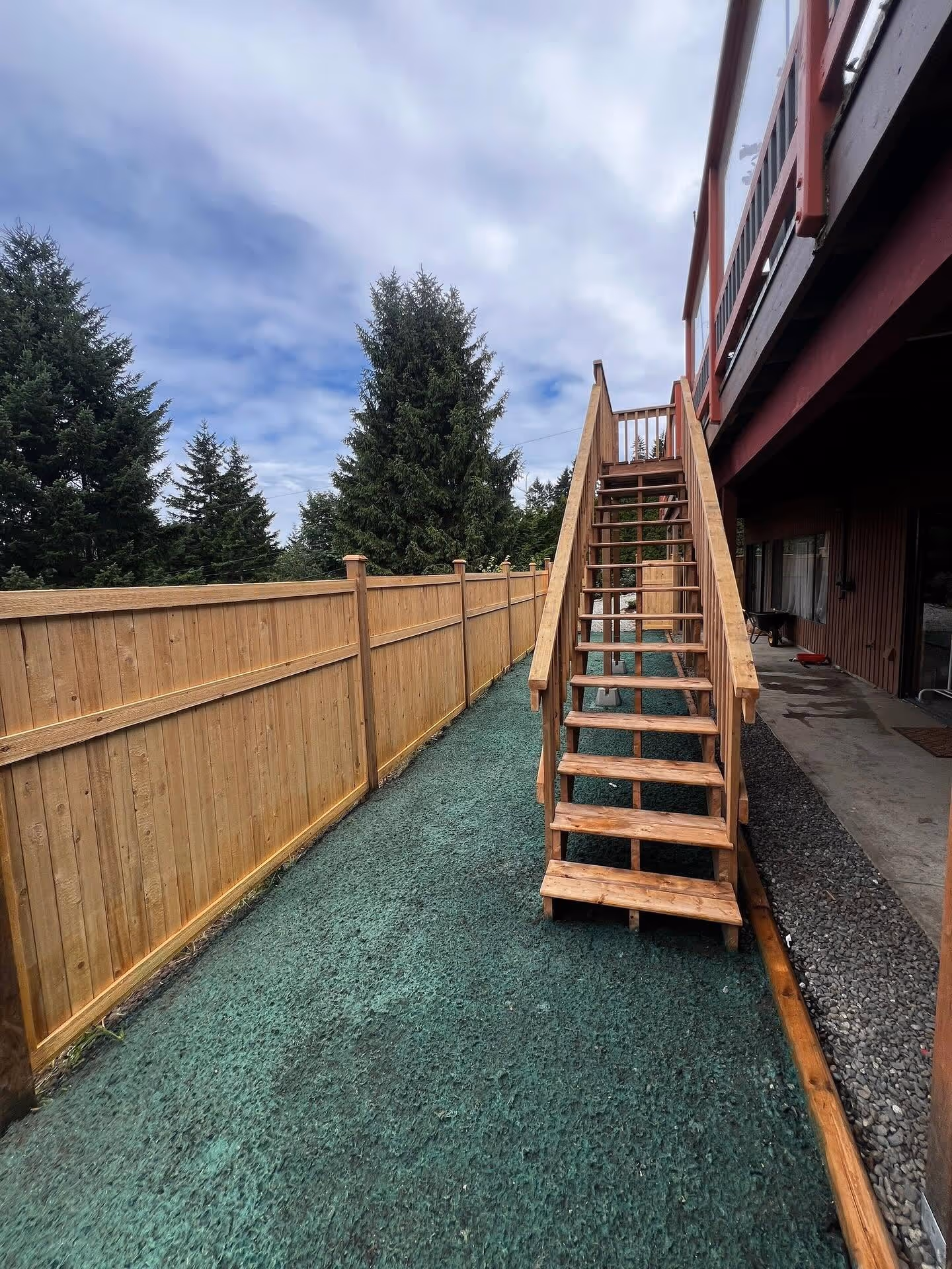 Cedar privacy fence and wooden stairs beside a rubber surface in Nanaimo