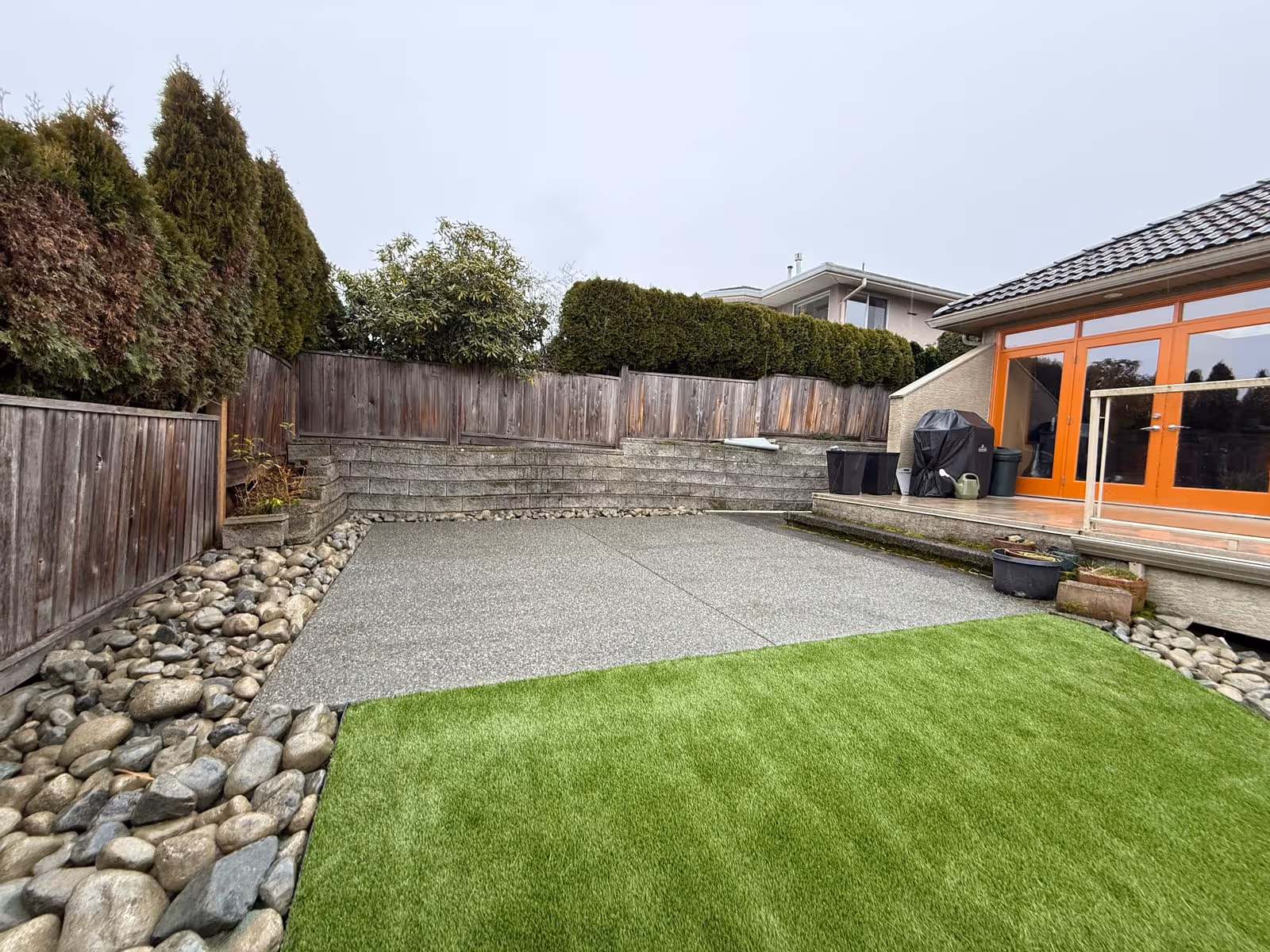 Artificial turf patio with a river rock border