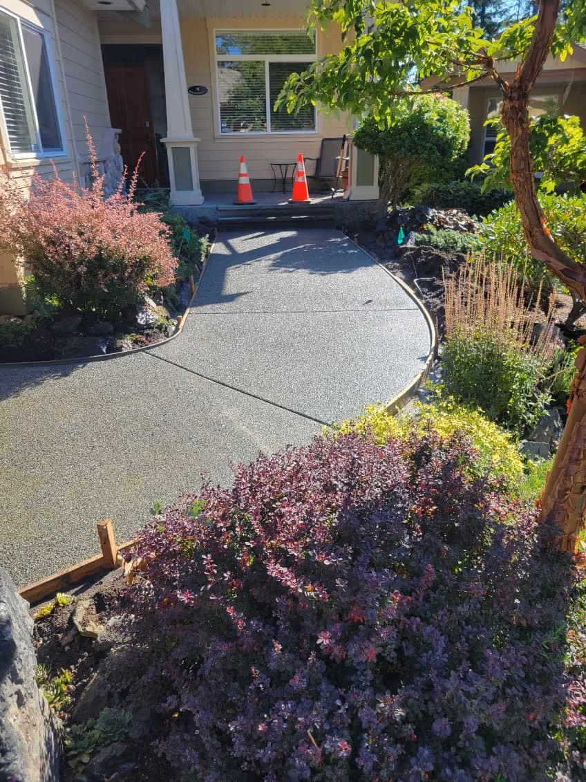 Exposed aggregate driveway with garden beds