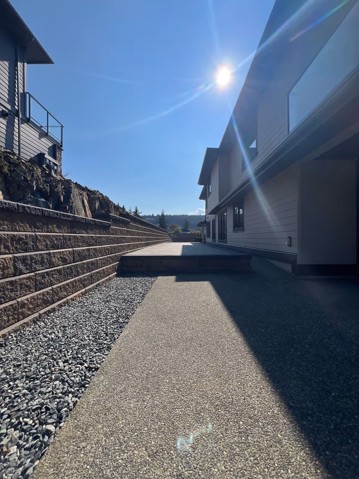 Exposed aggregate walkway beside a retaining wall
