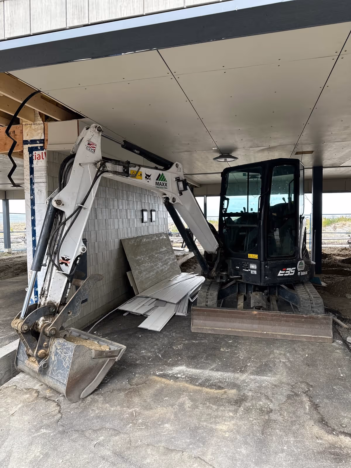 Compact excavator working beneath a building