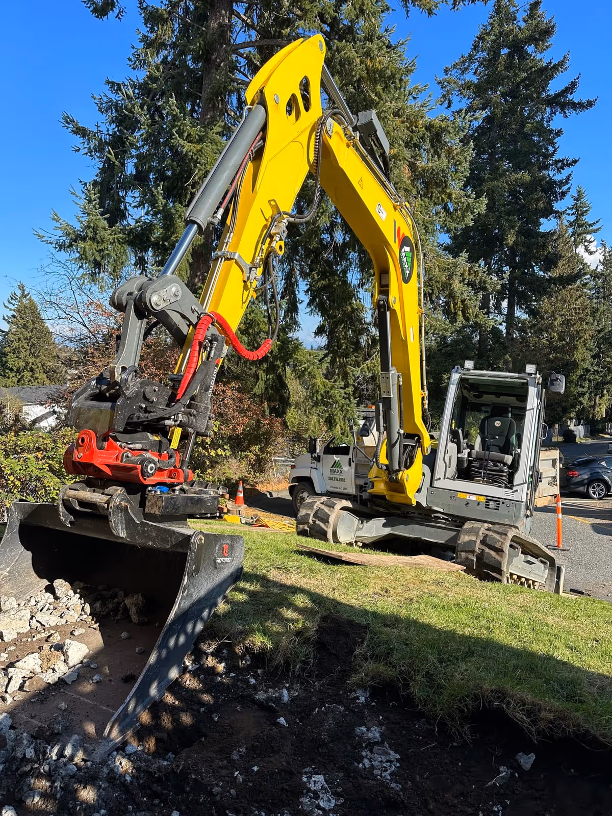 Excavator demolishing a concrete curb