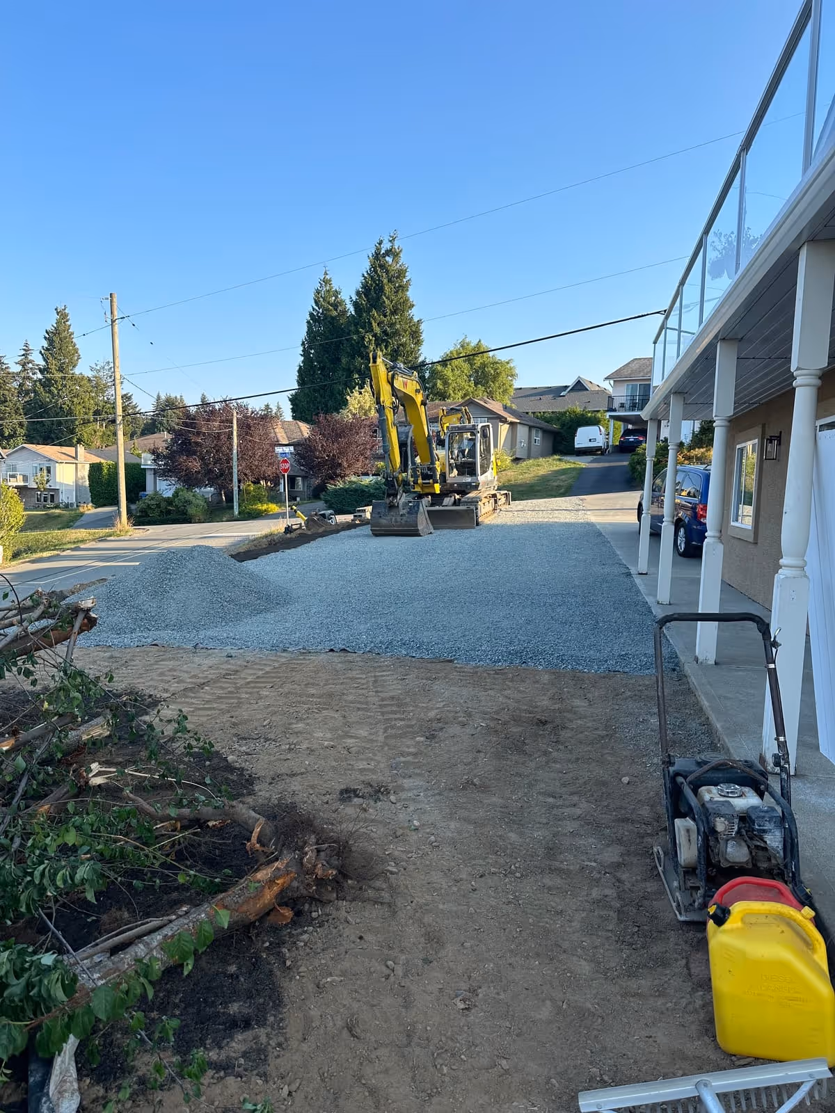 Excavator spreading gravel for a new driveway