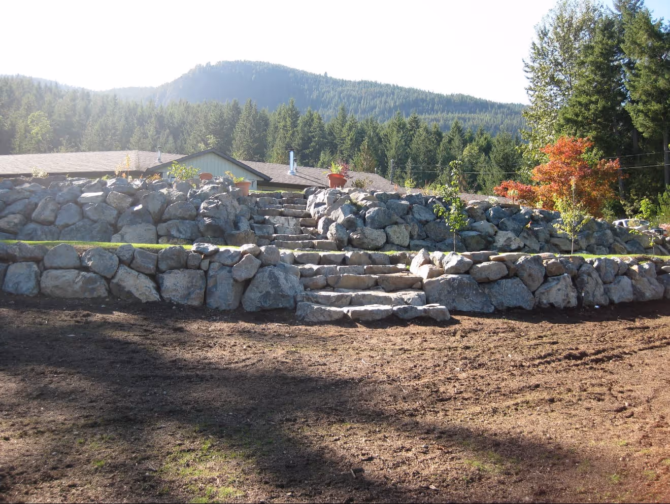 Boulder retaining wall with stone steps and a mountain view