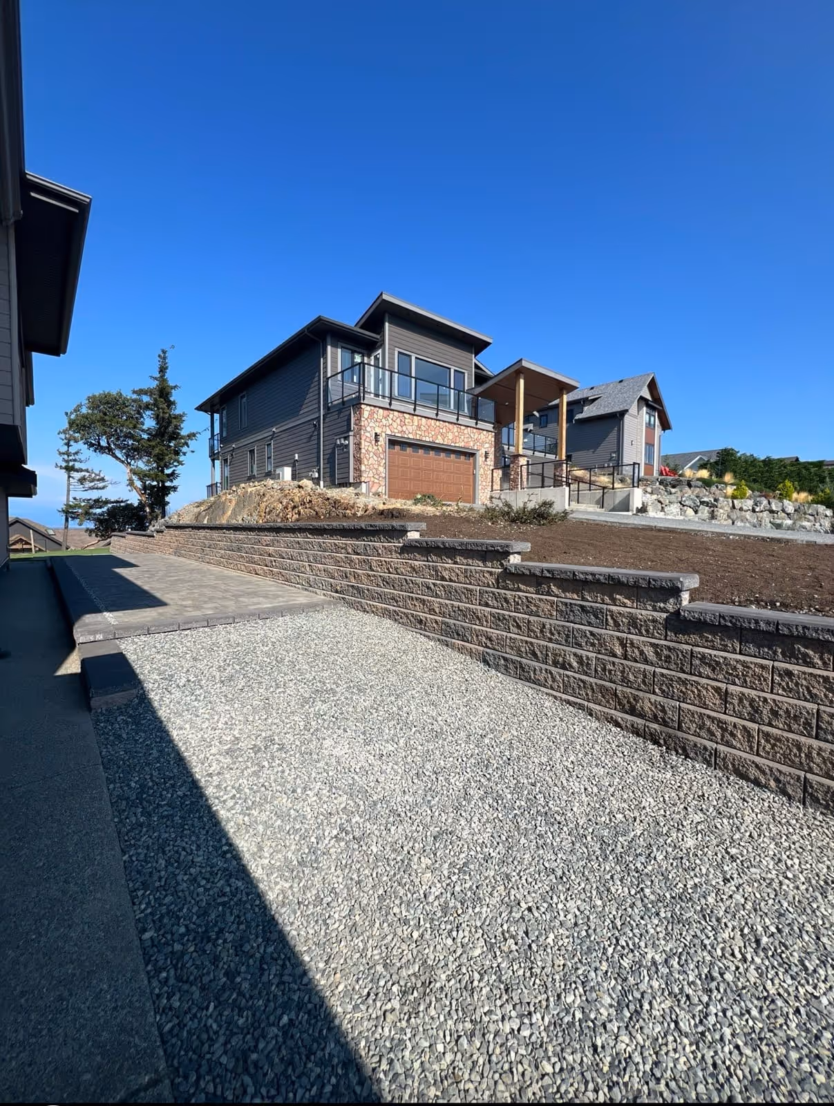 Dark block retaining wall on a gravel hillside