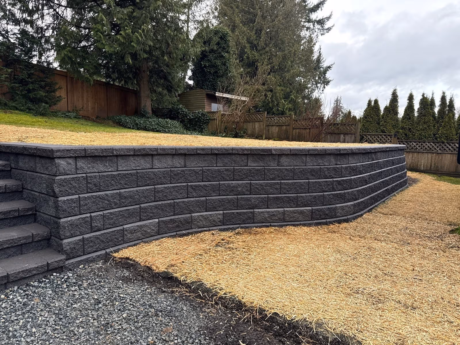 Dark block retaining wall with steps and mulch