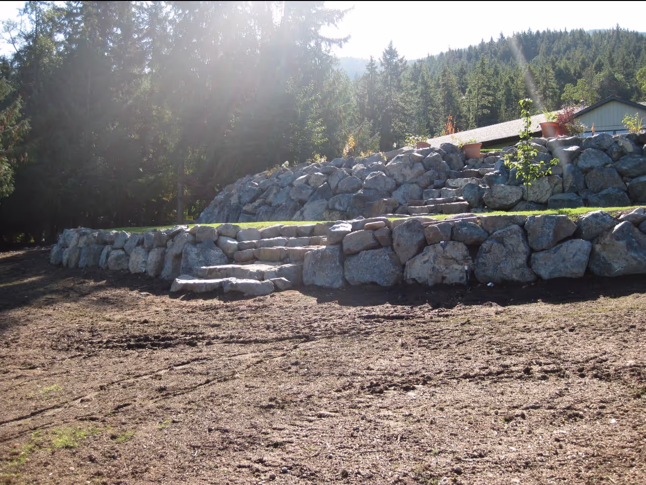 Large boulder retaining wall with natural stone steps