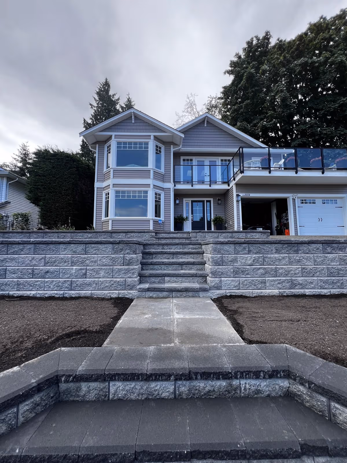 Stone block retaining wall with steps at a house entry