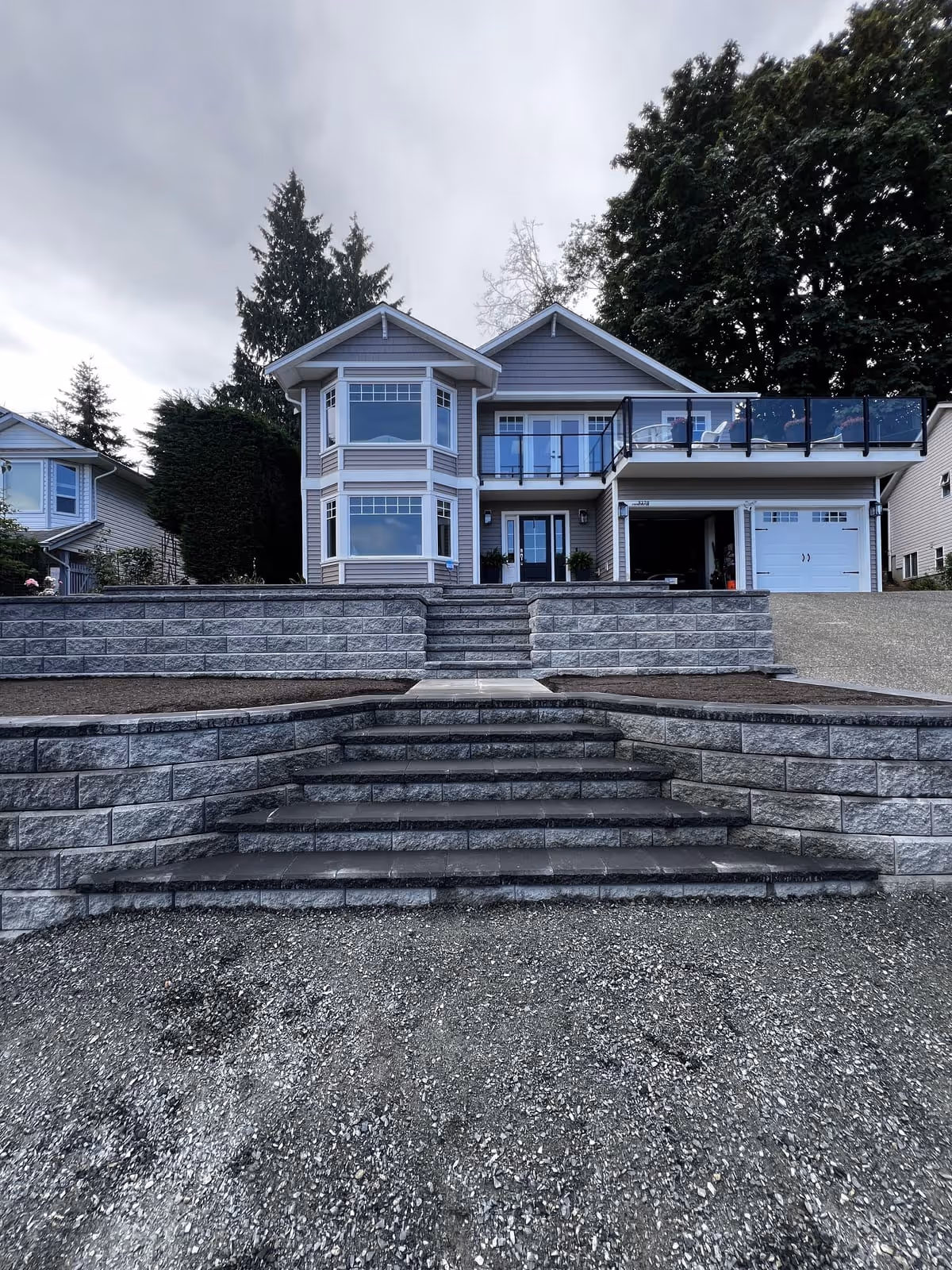 Tiered stone block retaining wall with steps at a house